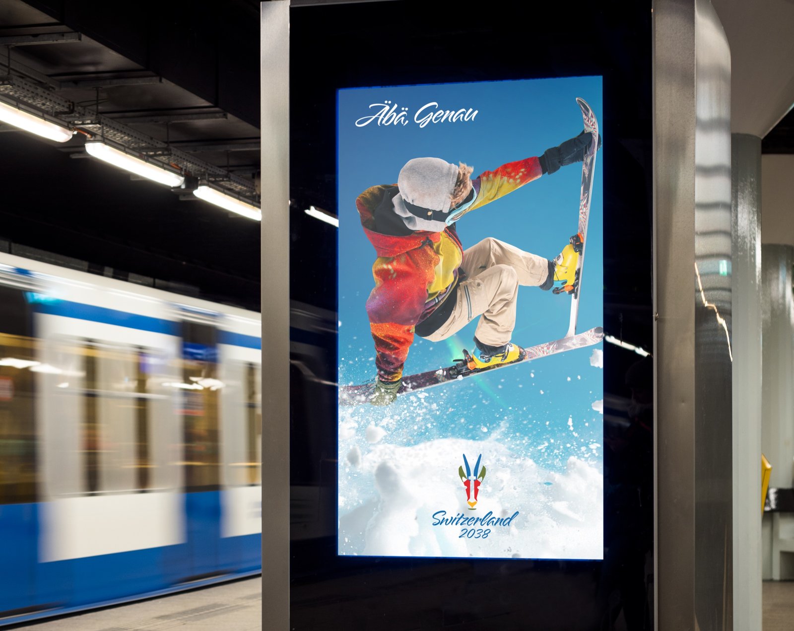 Digital display on a subway platform showing the &Auml;b&auml;, Genau snowboarder ad while a train passes